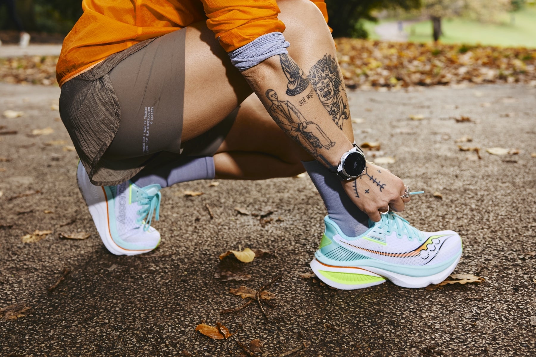 Eine Läuferin bindet sich in gehockter Haltung ihre Laufschuhe zu