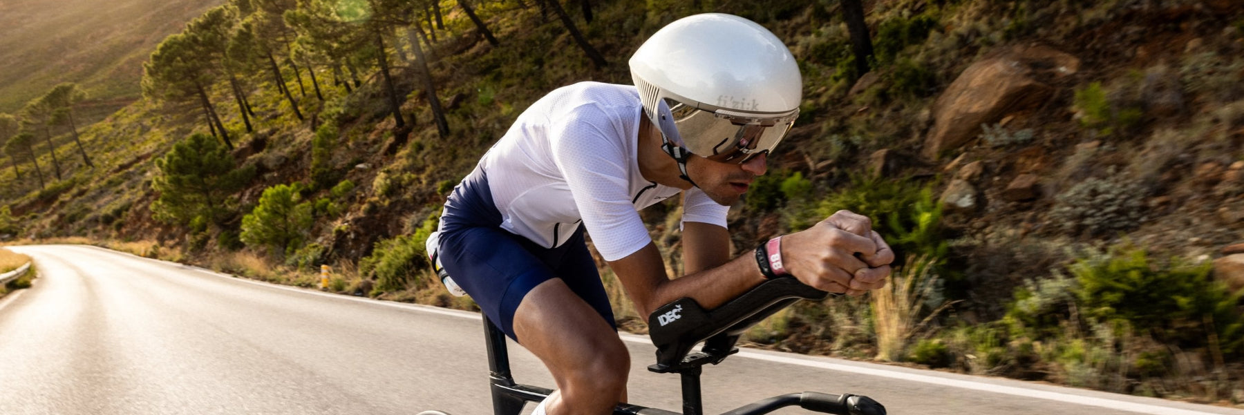 Ein Triathlet auf seinem Rad in Nahaufnahme von schräg vorn. Er liegt auf seinen Auflieger  in aerodynamischer Position.